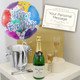 Personalised Champagne with Happy Birthday Balloon. A birthday celebration setup featuring a colorful "Happy Birthday" balloon, a bottle of champagne, two filled champagne flutes, and a card displaying the text "Your Personal Message." The arrangement is on a light-colored surface. Personalised Champagne with Happy Birthday Balloon. A birthday celebration setup featuring a colorful "Happy Birthday" balloon, a bottle of champagne, two filled champagne flutes, and a card displaying the text "Your Personal Message." The arrangement is on a light-colored surface.